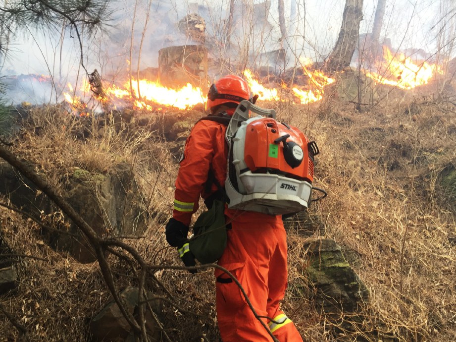 ANGGOTA bomba cuba mengawal kebakaran hutan di pedalaman kawasan pergunungan barat daya China.