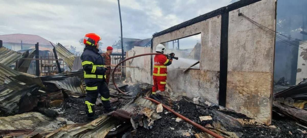 Anggota bomba memadam sisa kebakaran yang memusnahkan tujuh rumah dan sebuah kedai runcit di Kampung Tebobon Bukit, Kota Kinabalu. FOTO Ihsan Bomba