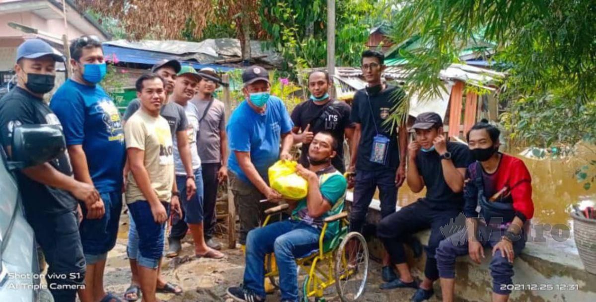 MUHAMMAD Azamirudin bersama rakan sukarelawan terbabit dalam misi bantuan banjir di Kampung Labohan Dagang dekat Sepang, baru-baru ini.