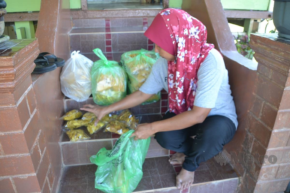 Noor Faridah menunjukkan kerepek pisang yang terselamat daripada dimusnahkan sekumpulan monyet yang mencerobohi rumahnya di Kampung Londang, Masjid Tanah. FOTO Hassan Omar