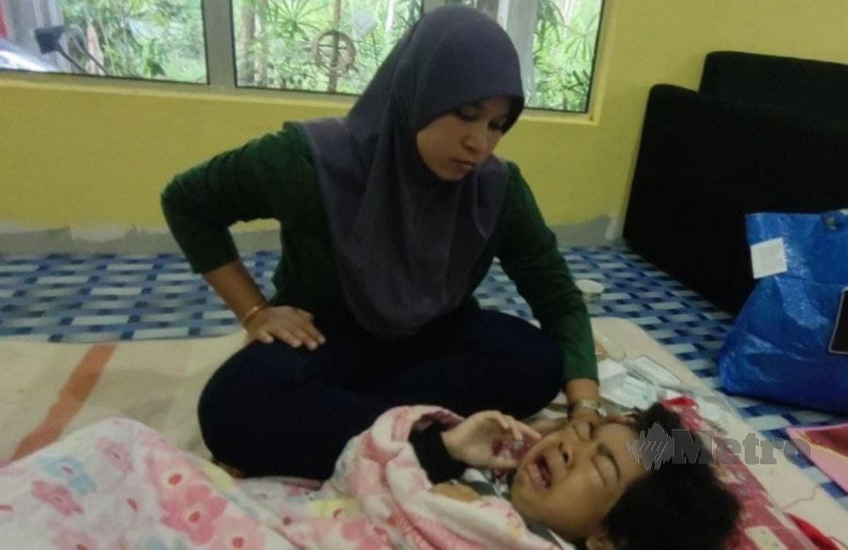 Nur Fadliza Zakaria, 31, bersama anaknya, Putri Noor Zafrina Batrisya Muhammad Azwan, 8, yang diuji masalah kebocoran buah pinggang ketika ditemui di rumahnya di Kampung Tasek Bakong, di sini, hari ini.FOTO SYAHERAH MUSTAFA