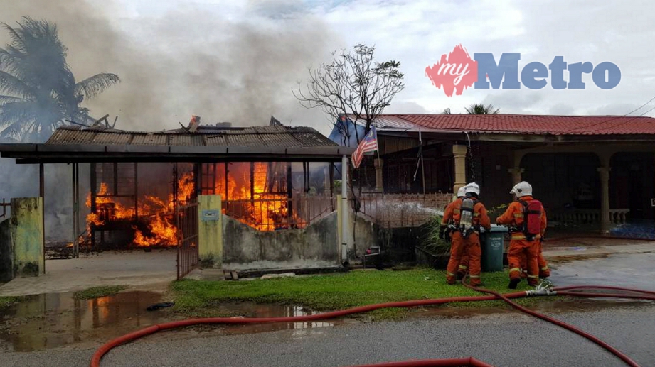 ANGGOTA Bomba dan Penyelamat bertungkus lumus memadamkan kebakaran yang memusnahkan tiga buah rumah penduduk di Perkampungan Sungai Isap 2 petang tadi. FOTO BERNAMA