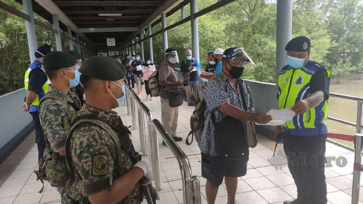 Polis melakukan pemeriksaan terhadap penumpang yang mempunyai surat kebenaran polis sebelum dibenarkan menaiki feri di Terminal Feri Kuala Kedah bagi mengelak ada yang mengambil kesempatan merentas daerah dan negeri tanpa kebenaran. FOTO ZULIATY ZULKIFFLI
