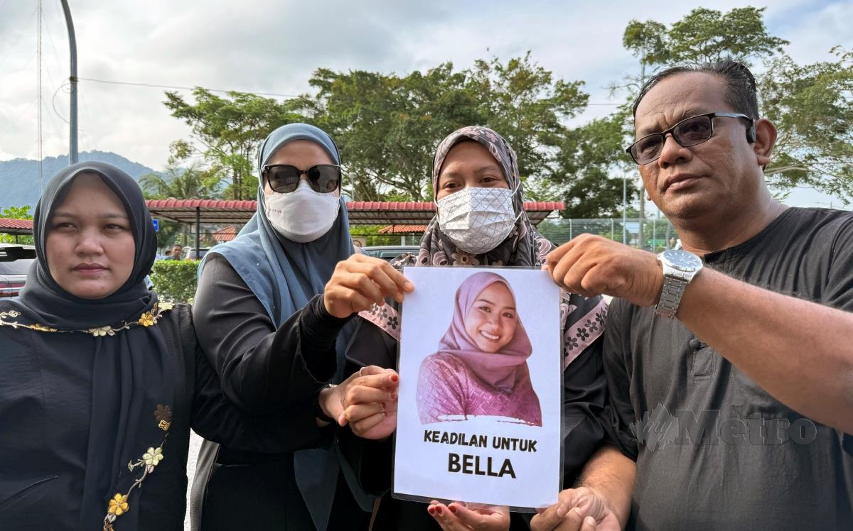 Ahli keluarga mangsa menunggu di luar mahkamah sambil memegang poster Mila Sharmila atau Bella di Mahkamah Batu Pahat, Johor. FOTO NUR AISYAH MAZALAN