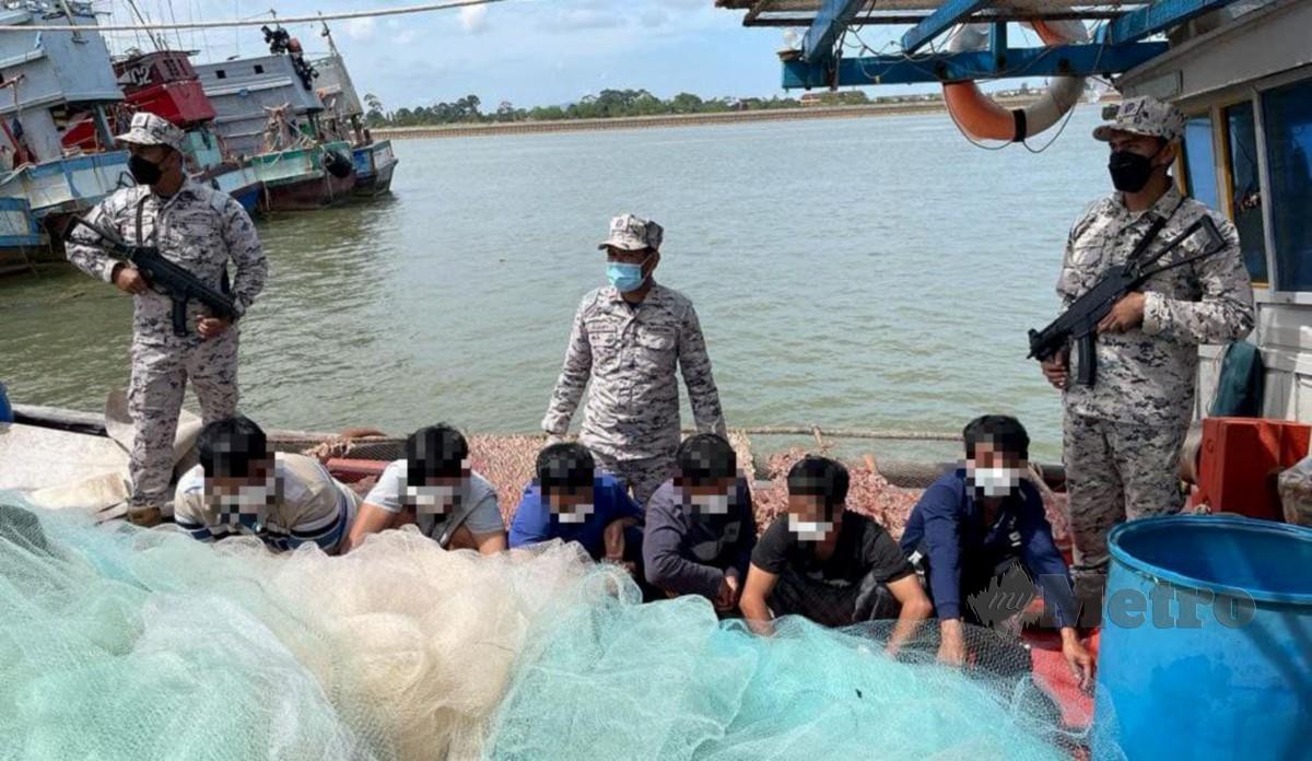 Muhammad Suffi (kiri) bersama pegawai dan anggota memeriksa dokumen enam nelayan Vietnam termasuk seorang bawah umur kerana menceroboh perairan negara. FOTO SAID SALIM