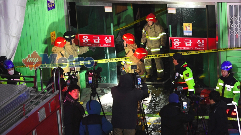 Pihak bomba berusaha memadam api di pintu masuk wad kecemasan Hospital Sejong, Miryang, Wilayah Selatan Gyeongsang, Korea yang terbakar pagi ini. FOTO AFP