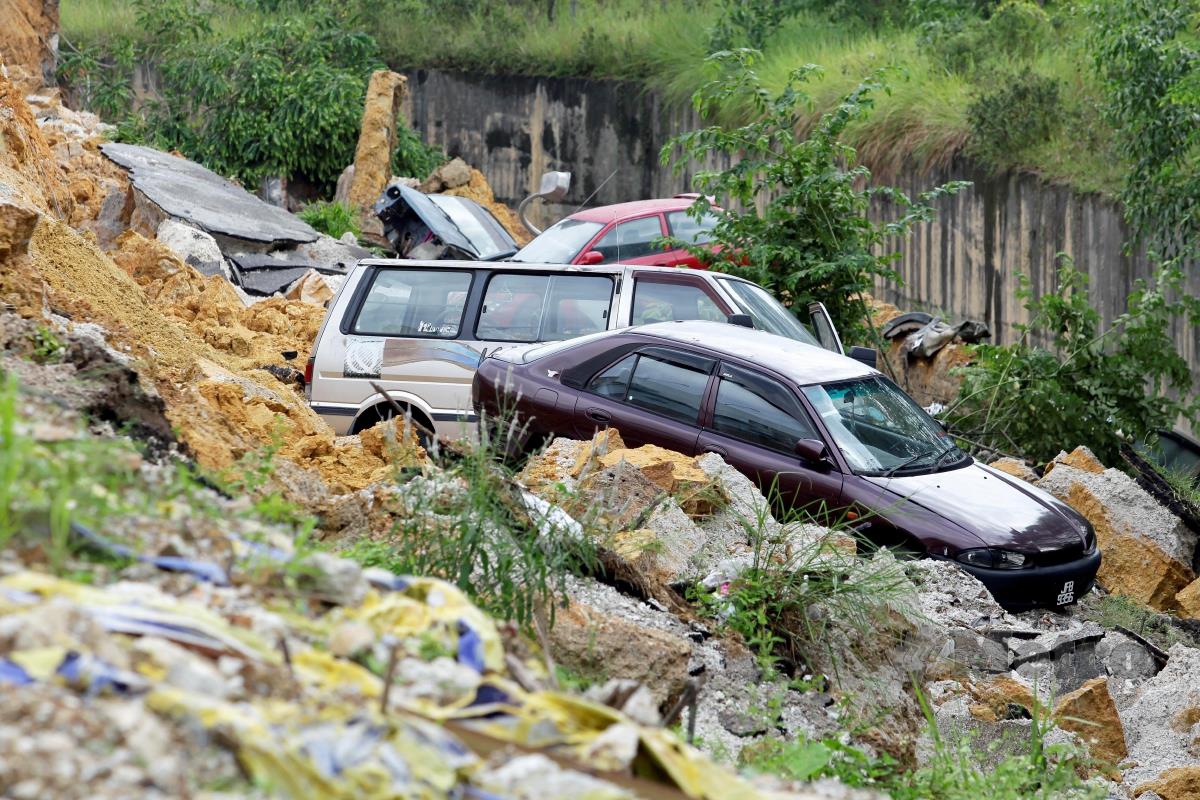 Kelihatan sebahagian jalan runtuh mengakibatkan lima buah kenderaan rosak ketika tinjauan kejadian tanah mendap di Lestari Perdana, Seri Kembangan. FOTO AIZUDDIN SAAD