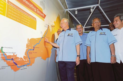 NAJIB diiringi Adenan (tiga dari kanan)  dan Fadillah  (empat dari kanan) melihat peta projek Lebuhraya Pan Borneo Sarawak selepas merasmikan fasa satu projek itu, semalam. 
