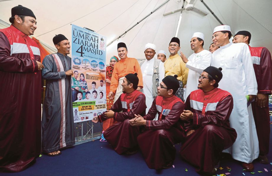 ABU Hassan (empat dari kiri) menunjukkan poster selebriti yang bakal menyertai Umrah dan Ziarah 4 Masjid.