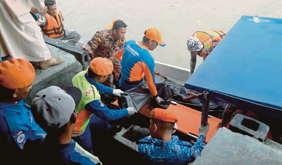 Anggota penyelamat mengangkat mayat Mohd Hafiz  yang ditemui nelayan selepas terjatuh dari bot ketika memancing pada Sabtu lalu.