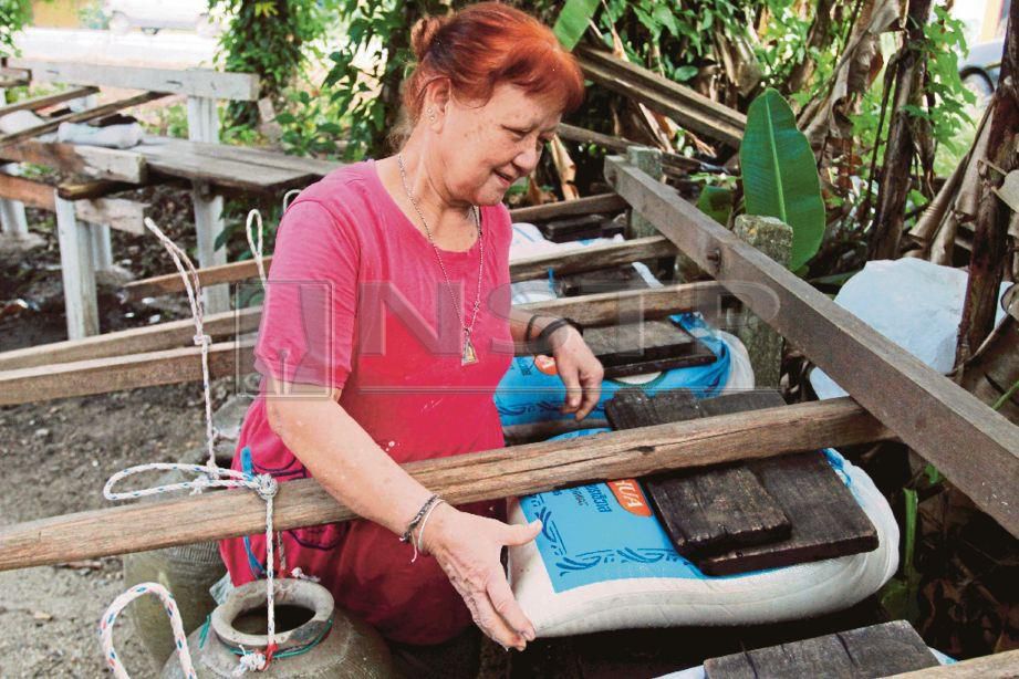EWO menggunakan kaedah ‘manual’ dan tradisional untuk menghasilkan tepung pulut untuk tempahan di musim perayaan Tahun Baharu Cina di halaman rumahnya di Wakaf Bharu, Tumpat.