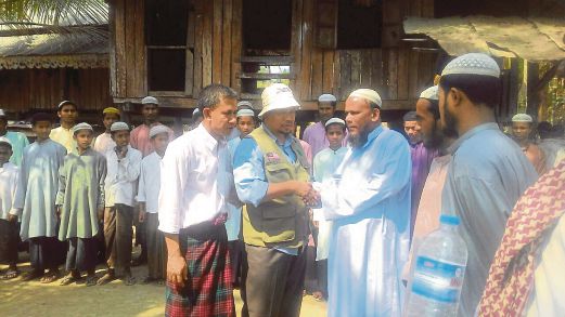 AHMAD Tarmizi (dua dari kiri) bersama penduduk kampung di Arakan. 