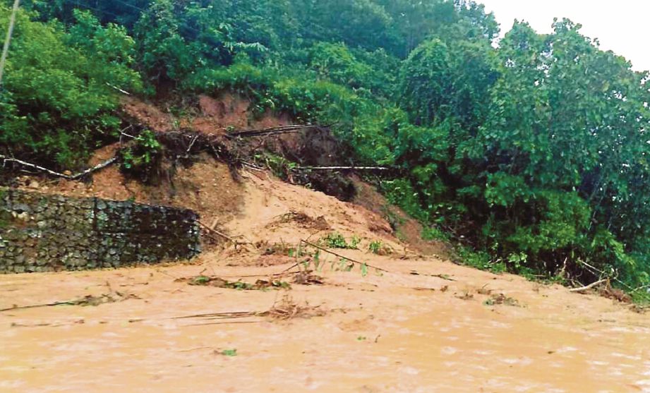 TANAH runtuh yang menutupi permukaan Jalan Tamparuli-Ranau. 
