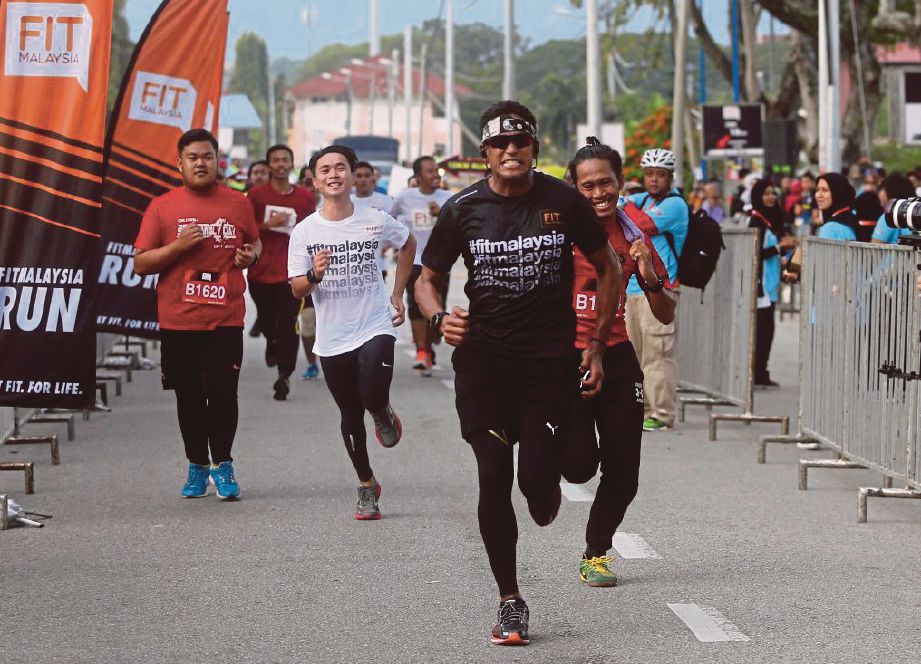 KHAIRY (tengah) bersaing bersama peserta ke garisan penamat ketika menyertai Larian Fit Malaysia  pada Program Fit Malaysia Fasa 2 Johor di Stadium Batu Pahat, kelmarin.