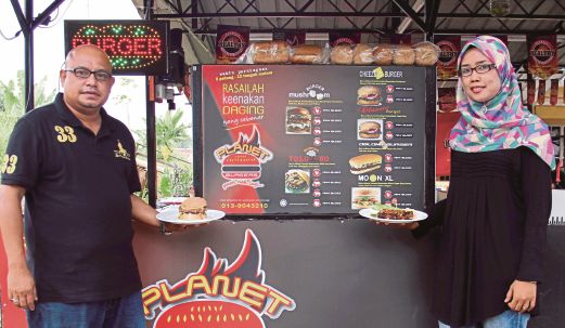 KHAIRINA Sari Khairuddin (kanan) memperkenalkan hidangan terbaru Grill Chicken Chop dan Ramlee (kiri)  bersama hidangan terbaru Moon Xl Burger.