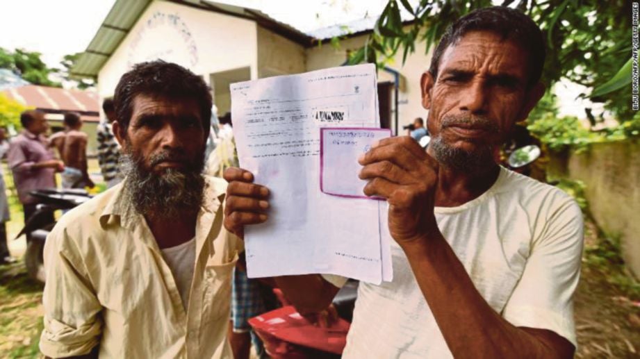 SEORANG penduduk menunjukkan dokumen sebelum memeriksa namanya dalam senarai Pendaftar Kewarganegaraan Kebangsaan di kampung Kuranibori kelmarin. FOTO AFP
