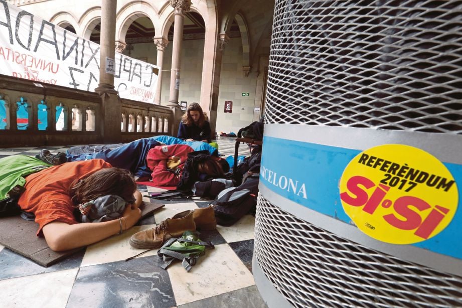 AKTIVIS tidur di bangunan Universiti Barcelona lokasi pusat pengundian undi bagi pungutan suara. - Reuters