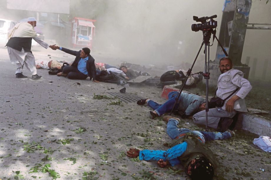 BEBERAPA wartawan dilihat cedera sejurus letupan kedua yang menyasarkan pengamal media yang membuat liputan di lokasi serangan bom berani mati di Kabul semalam. - Reuters