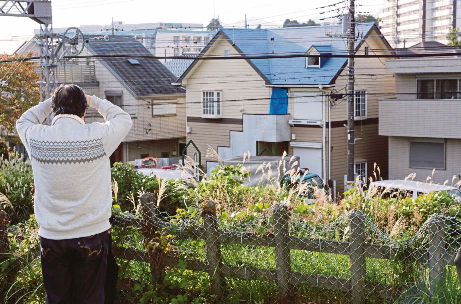 SEORANG penduduk melihat rumah lokasi sembilan mayat ditemui dipotong dan dipenggal di Zama, Kanagawa Jepun semalam. - EPA