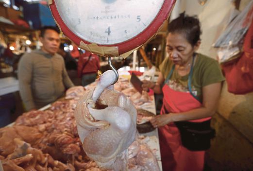 SEORANG peniaga memotong ayam untuk seorang pelanggan di Pasar Senen, Jakarta, semalam.  