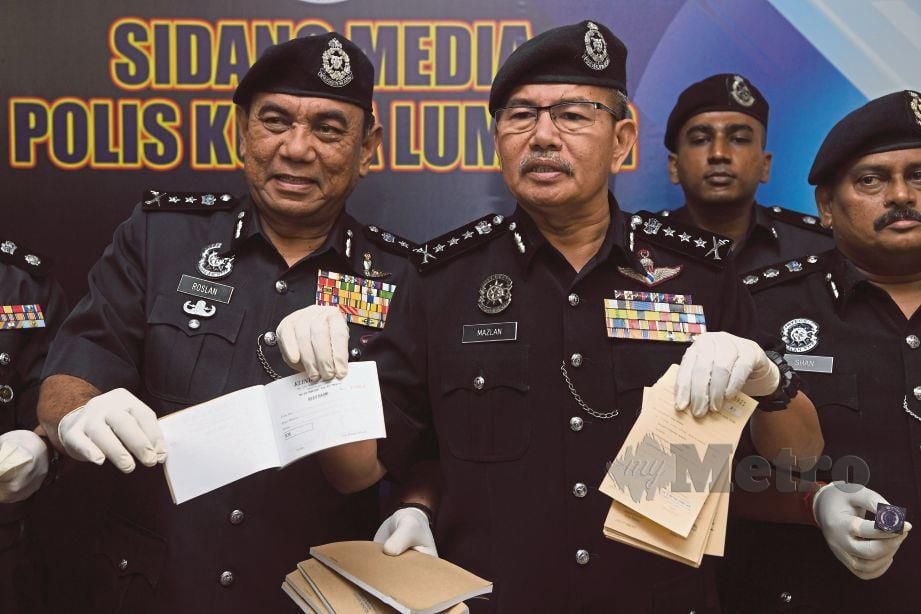 MAZLAN  (kanan)  menunjukkan antara sijil cuti sakit yang palsu yang dikeluarkan  sindiket ketika sidang media  di IPK  Kuala Lumpur, semalam.