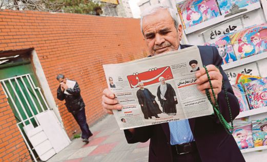 SEORANG lelaki membaca akhbar yang menyiarkan berita kemenangan kumpulan pro-Presiden Hassan dan bekas Presiden Akbar Hashemi Rafsanjani di Teheran, semalam.   