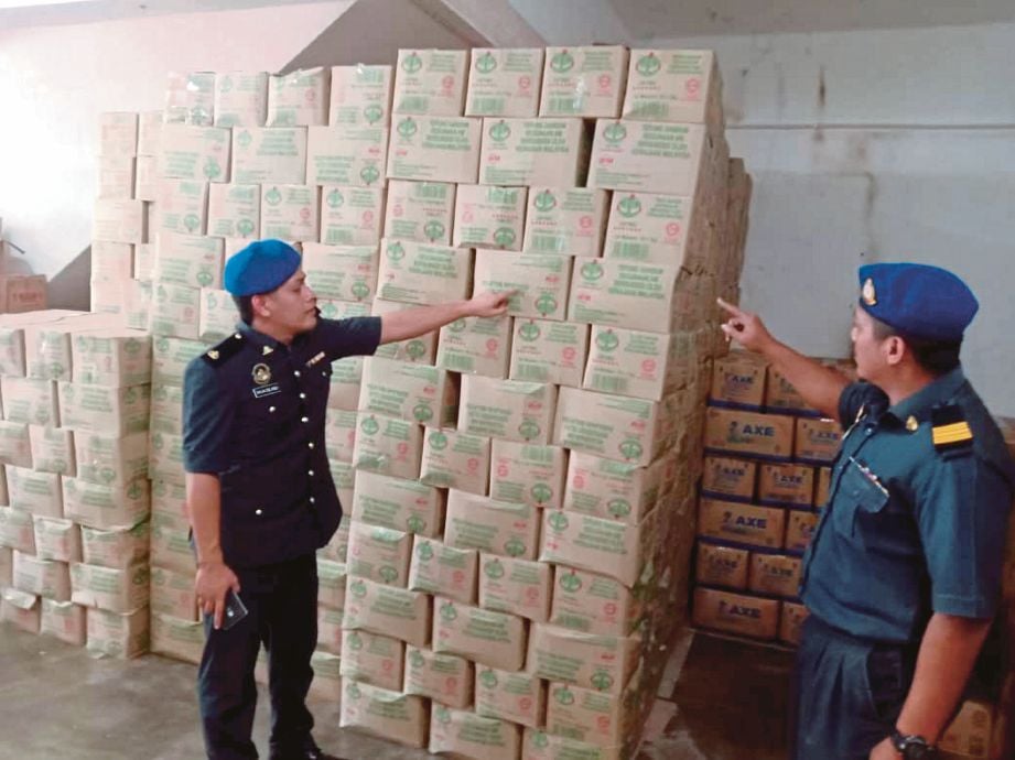 KETUA Unit Kawalan Bekalan KPDNHEP Kelantan, Raja Zul Raja Yaacob (kiri) memeriksa barang kawalan yang dirampas. FOTO ihsan KPDNHEP Kelantan