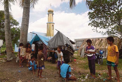 SEBAHAGIAN penduduk berehat di khemah  berhampiran sebuah masjid yang dijadikan tempat perlindungan sementara di Maguindano sebelum dibenarkan pulang ke rumah masing-masing. 