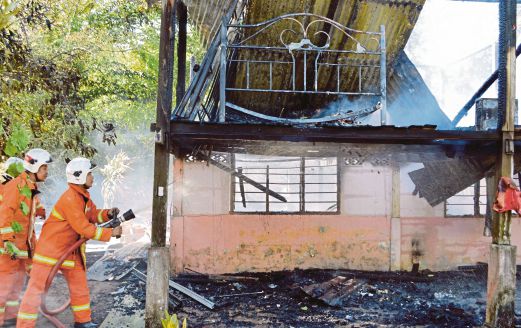 ANGGOTA bomba memadamkan kebakaran di rumah milik Ros Ayu.