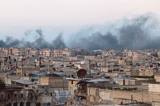 KEPULAN asap memenuhi ruang angkasa kejiranan al-Sakhour selepas serangan udara di kawasan itu, semalam. 