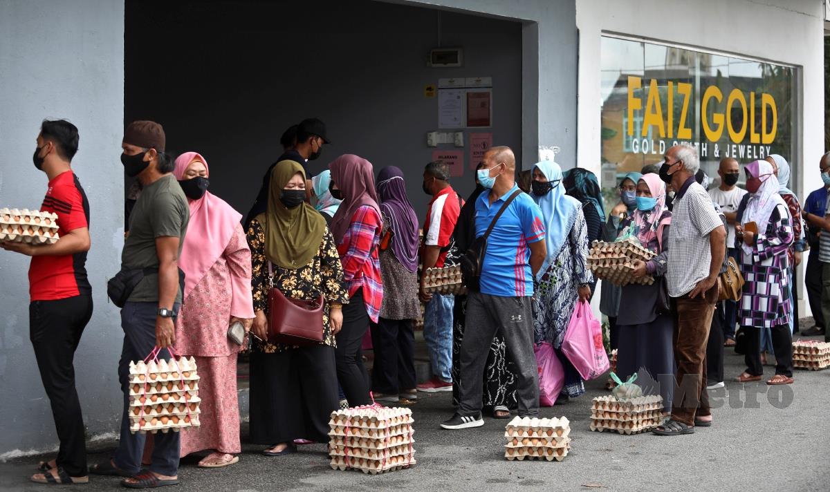 Orang ramai beratur untuk membeli telur ayam di kedai di Kampung Chabang Tiga. FOTO GHAZALI KORI