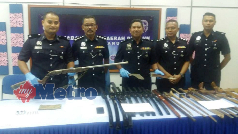 KETUA Polis daerah Dungun, Superintendan Baharudin Abdullah (tiga dari kiri) menunjukkan pelbagai jenis parang dan pedang serta senapang yang dirampas dalam dua kes tangkapan di Dungun, hari ini. FOTO Rosli Ilham