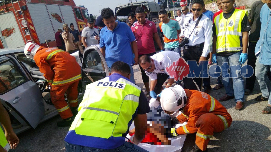 ANGGOTA Bomba dan polis mengangkat mangsa pemandu Proton Persona, Azmi Mohamad Noor, 49 yang maut dalam kemalangan terbabit dengan sebuah lori minyak di Kilometer 35, Jalan Dungun-Bukit Besi di persimpangan Lay Bay Bukit Besi. FOTO Rosli Ilham