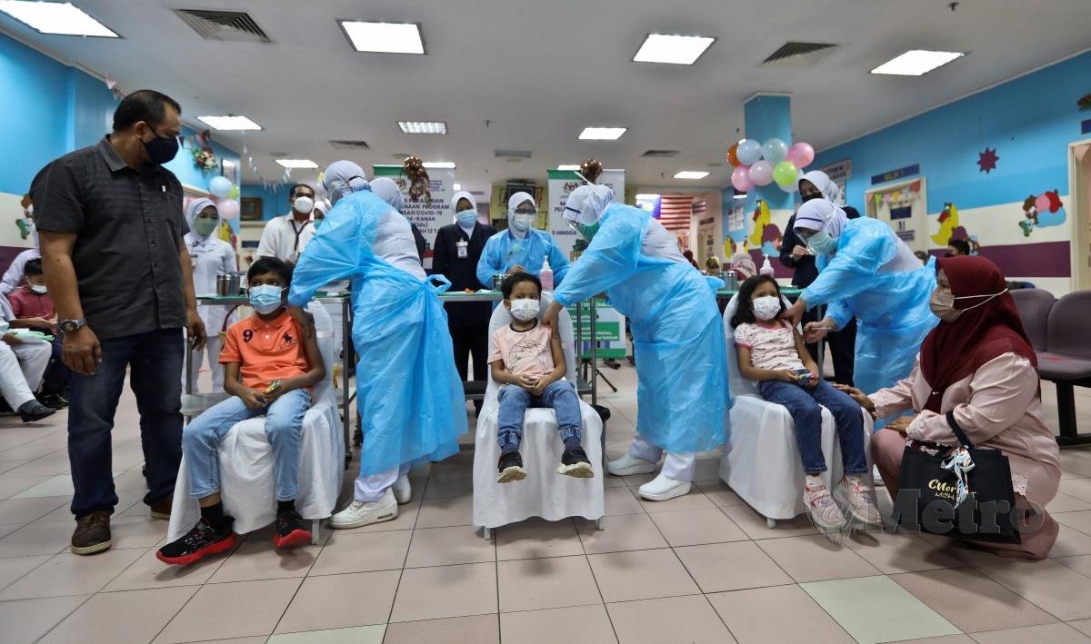 Nazriel Ariqin bin Kamarul Azhar, 5 (tengah),   Nazeef Audric, 9 (dua kiri) dan Nurlisa Maureen, 6 bersama ibu, Nor Ruziah Ismail,  46 dan Kamarul Azhar Zainun, 47 semasa menjalani suntikan Vaksin pada Program Imunisasi Covid-19 Kanak-Kanak (PICKids) Peringkat Negeri di Hospital Sultanah Nur Zahirah (HSNZ) hari ini. FOTO GHAZALI KORI
