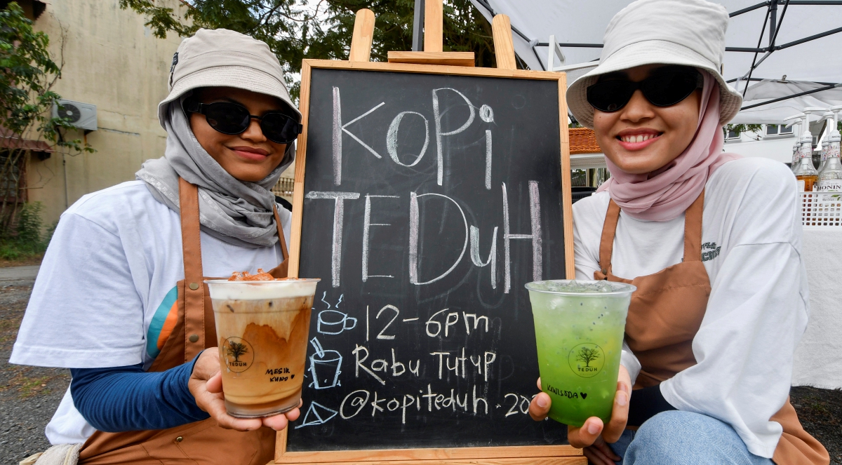 Siti Nurashakila (kiri) dan Intan Zulsyawani menunjukkan sebahagian minuman yang dijual mereka ketika ditemui Bernama di gerai Kopi Teduh di Taman Maju di sini. FOTO BERNAMA