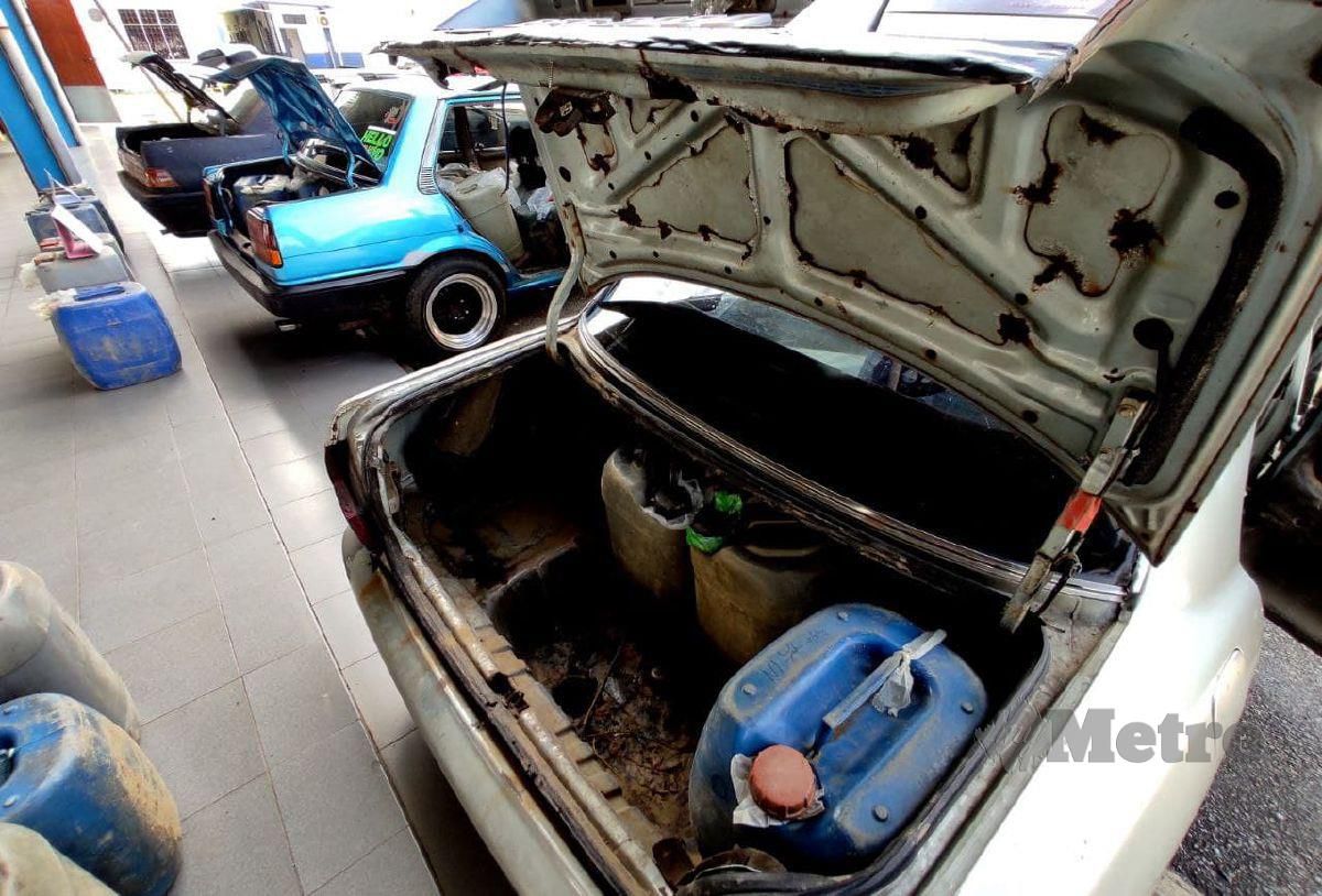 Tiga kenderaan jenis Proton Iswara, Wira dan Toyota LE dikesan menemui 59 tong berisi minyak petrol dengan kandungan 1,740 liter yang dianggarkan bernilai RM6,858.30 sekaligus membongkarkan aktiviti penyeludupan minyak petrol. FOTO NIK ABDULLAH NIK OMAR