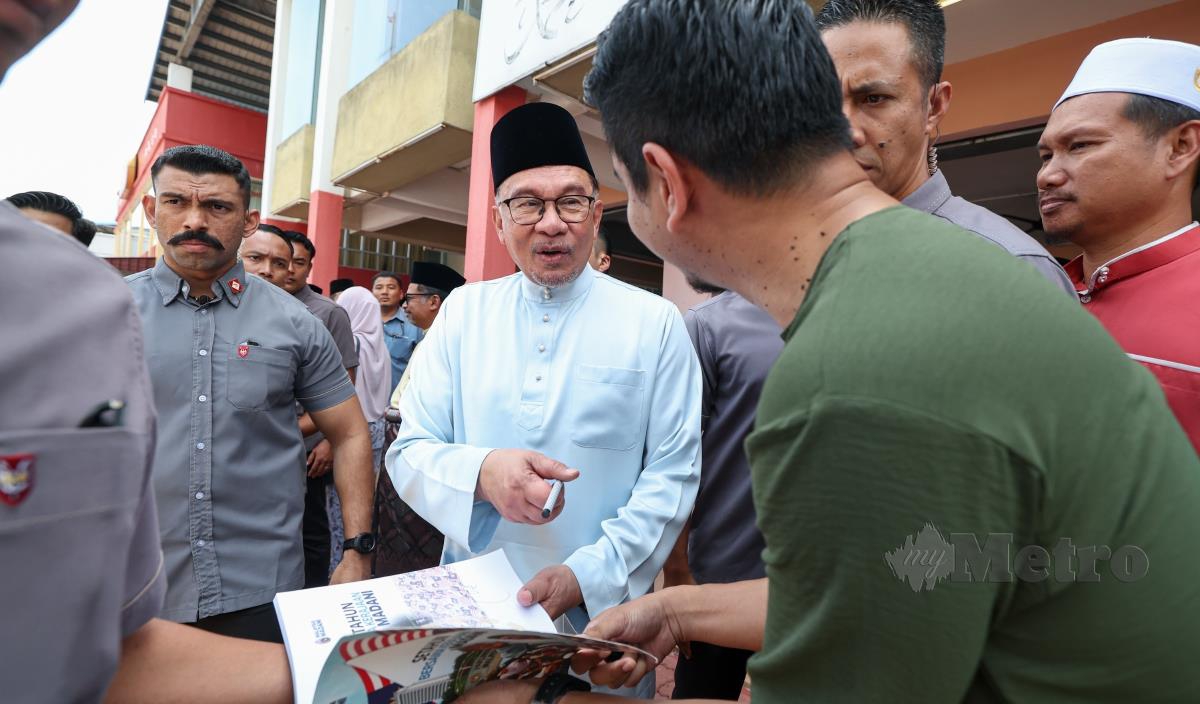Perdana Menteri Datuk Seri Anwar Ibrahim beramah mesra bersama pengunjung restoran selepas selesai makan tengah hari bersama rakyat di Restoran Asam Pedas Ibu Ani Parit Jawa di Ayer Keroh hari ini. FOTO BERNAMA