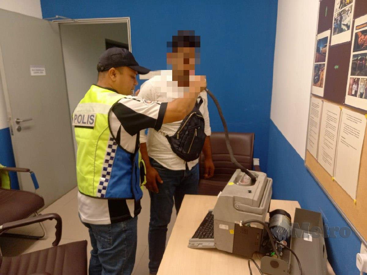 Anggota polis menjalankan ujian pernafasan menggunakan alat EBA ll terhadap kedua-dua individu berkenaan. FOTO Ihsan IPD Ampang Jaya