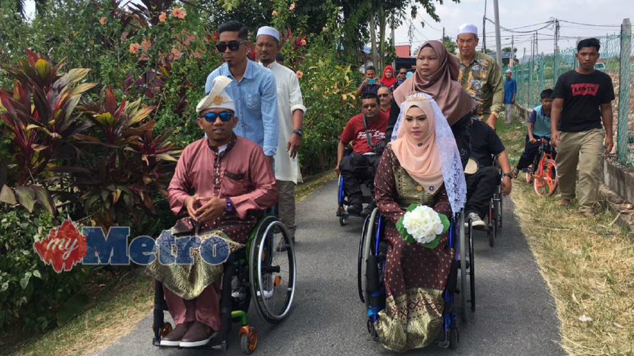 PASANGAN pengantin OKU, Amin Ridzuan Che Mohamad, 31 dan  Siti Nor Azizah Abdul Aziz, 29, semasa majlis perkahwinan mereka di Kampung Menerong, Pokok Sena. FOTO Noorazura Abdul Rahman