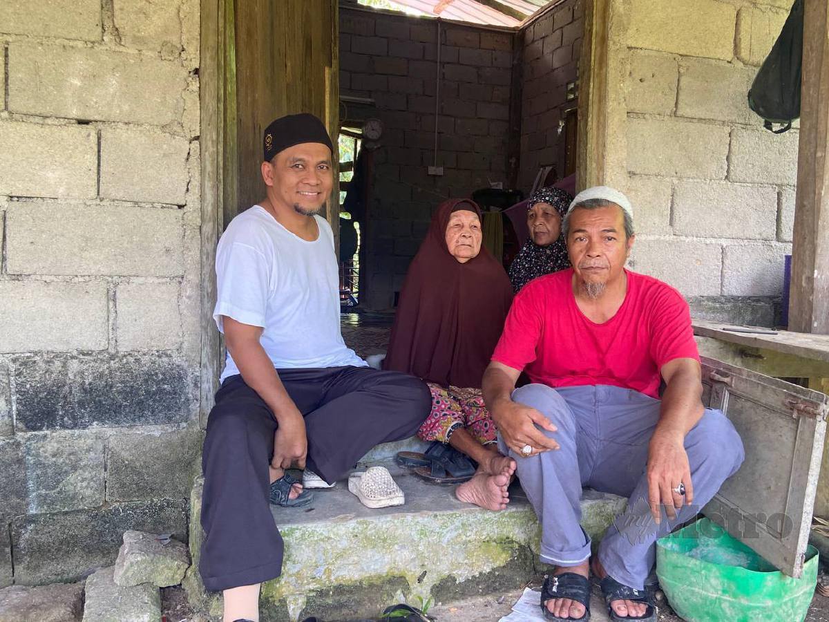 Zulkifli Hussin (kanan) bersama ibunya, Minah Mamat (tengah) dan turut ditemani Pengasas Yayasan Raja Shamri (YRS) Raja Shamri Raja Husin (kiri) berada di rumah lama mereka di Kampung Tasek Bakong. FOTO HAZIRA AHMAD ZAIDI