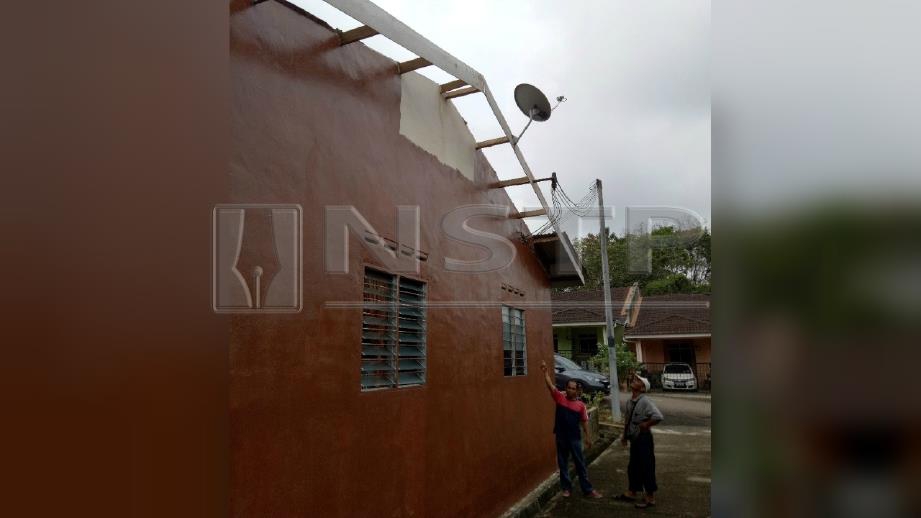 ANUAR Ahmad menunjukkan bumbung kediaman yang diterbangkan ribut di Taman Seri Cahya Buloh Kasap.  FOTO Ahmad Ismail