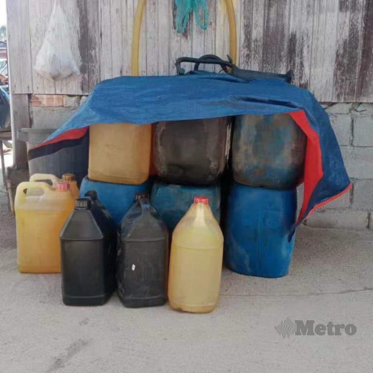 Sejumlah tong plastik yang mengandungi 345 liter diesel yang diletakkan di hadapan sebuah rumah di Kampung Telaga Lanas, Pengkalan Kubor yang dijadikan lokasi transit sebelum diseludup. FOTO IHSAN KPDN