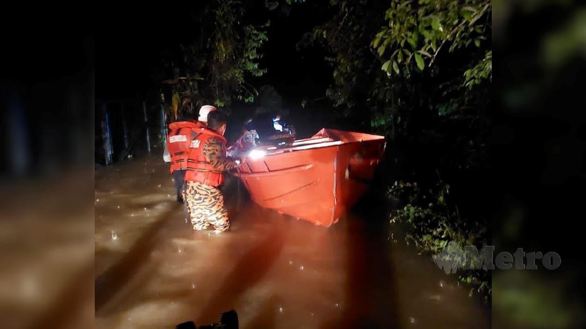 Jabatan Bomba dan Penyelamat Malaysia (JBPM) daerah Kuala Krai memindahkan mangsa banjir di Kampung Sungai Durian, Kuala Krai, malam tadi. FOTO IHSAN BOMBA