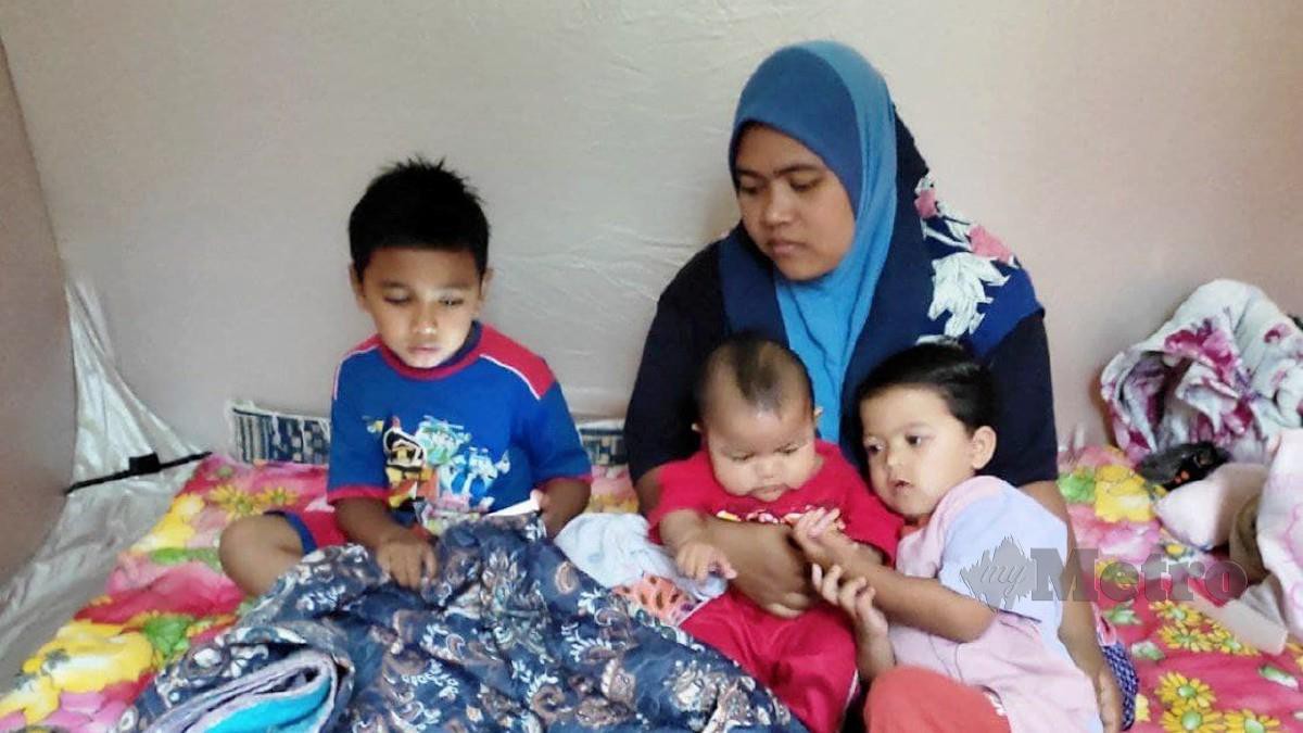 Rozieta Ismail, 32 bersama anak sulungnya, Nik Muhammad Adam Hafiz Haikal Nik Soh, 8,  serta dua anak yang lain di PPS Kampung Gong Duek, Besut, di sini, hari ini. FOTO Nurul Fatihah Sulaini