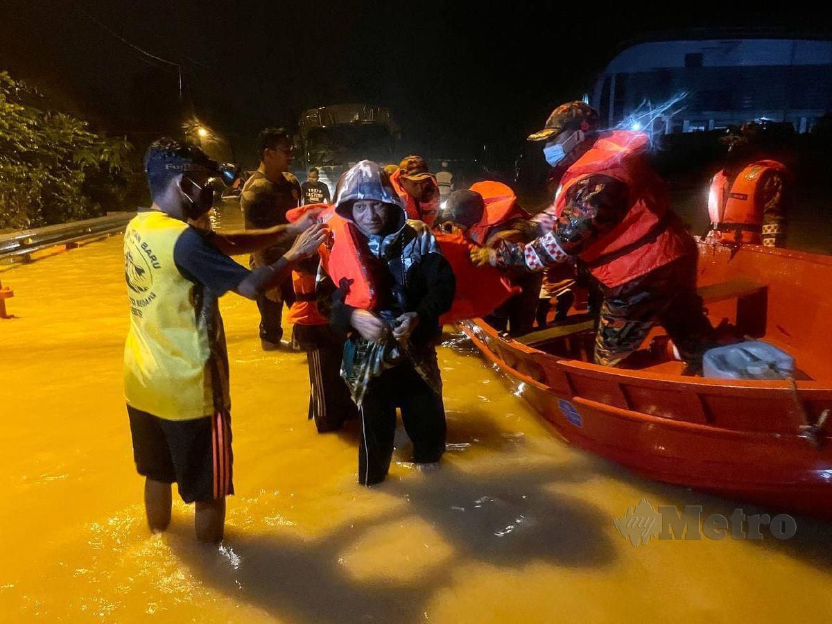 Anggota Bomba dan Penyelamat (JPBM) membantu menyelamatkan penduduk yang terperangkap dalam banjir selepas rumah mereka dinaiki air di Kampung Paya Besar, Kuala Berang malam tadi. FOTO GHAZALI KORI