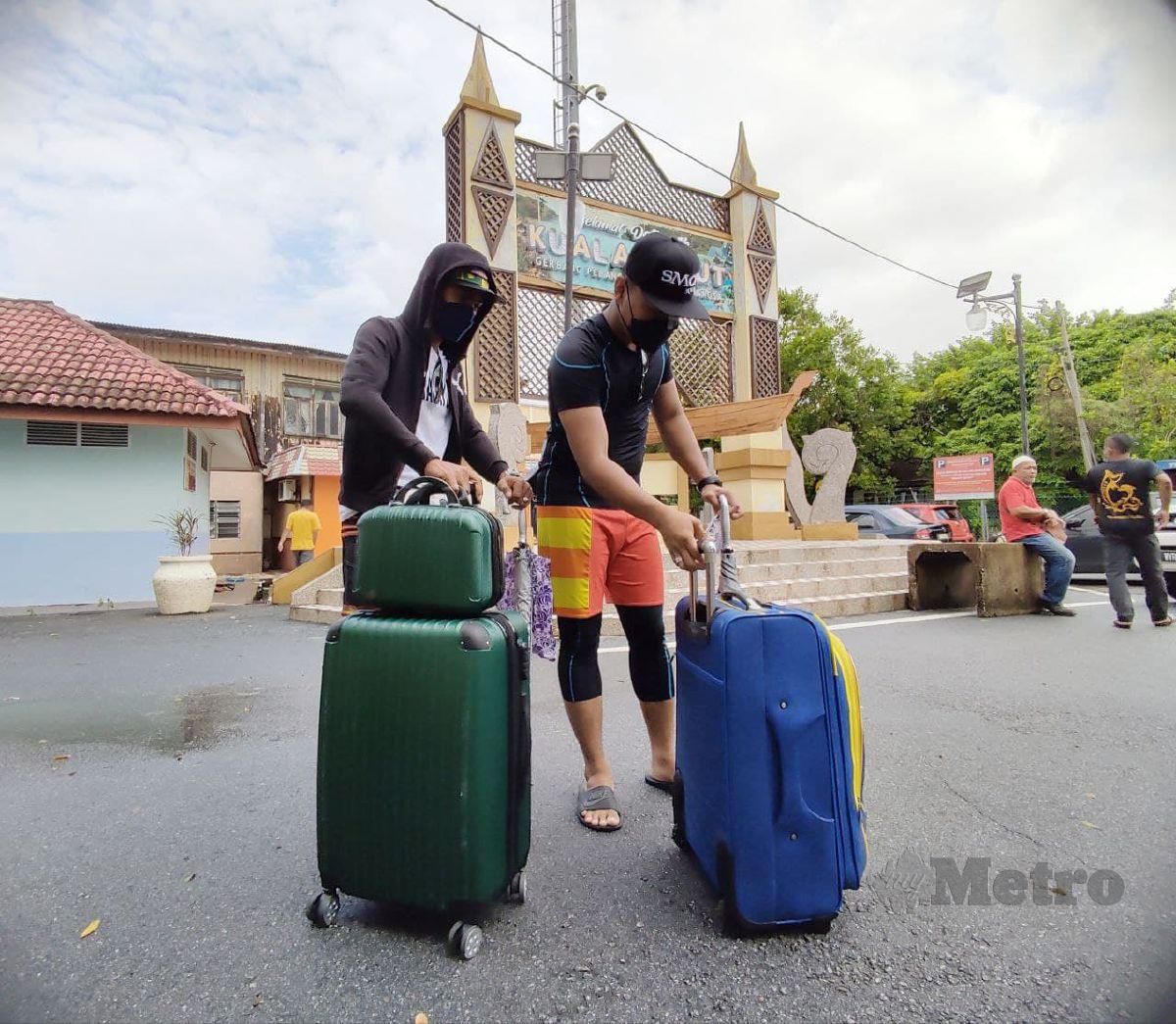Pelancong terkandas di Pulau Perhentian Shamsul Hafiz,30, (kiri) bersama rakan selamat tiba di Jeti Kuala Besut pagi ini. FOTO Nurul Fatihah Sulaini