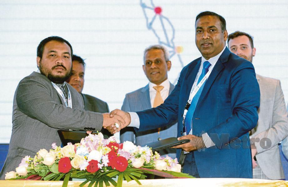 DR Mohamad Zaini  (kiri) bertukar dokumen perjanjian persefahaman dengan  Latt pada Persidangan Malaysia-Myanmar Connect 2019 di  Yangon.