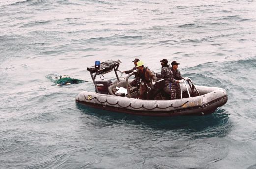 ANGGOTA TNI menunda mayat selepas ditemui terapung jauh di Laut Jawa.