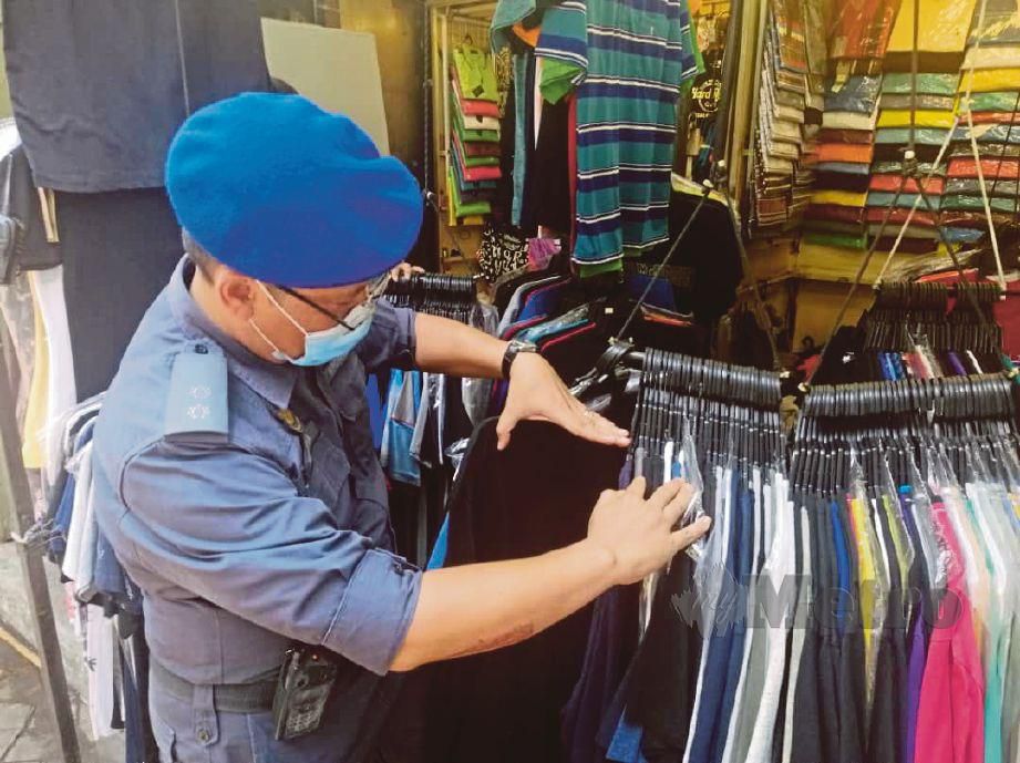 PEGAWAI KPDNHEP merampas pelbagai barangan jenama tiruan ketika serbuan di Jalan Petaling .