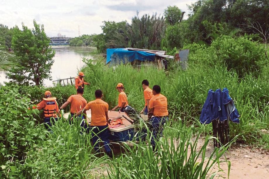 Anggota penyelamat mengangkat bot untuk operasi pencarian mangsa lemas  di Ampang Jajar, Butterworth. 